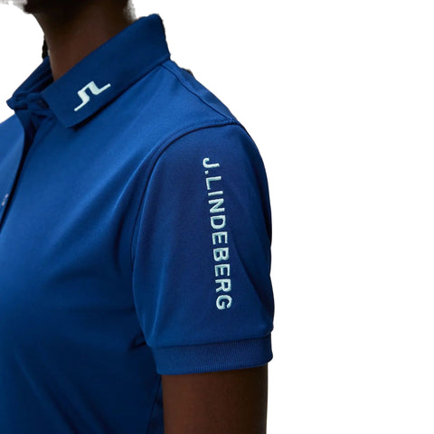 Nahaufnahme eines blauen Polohemds der Marke J. Lindeberg mit weißem Logo-Detail