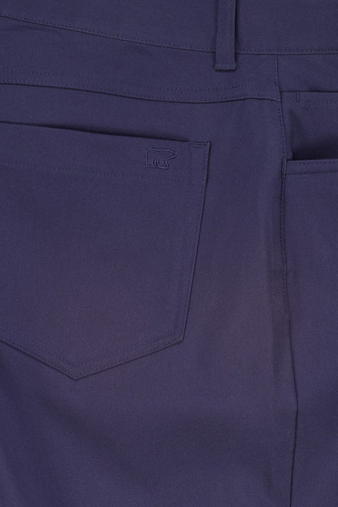 Nahaufnahme einer dunkelblauen Hose mit Fokus auf die hintere Tasche, die ein subtiles Bären-Logo-Stickerei zeigt und hochwertige Nähte demonstriert