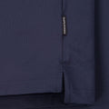 Nahaufnahme eines dunkelblauen Sweatshirts oder Pullovers mit sichtbarem 'Peak Performance' Etikett und detaillierter Ansicht der Stofftextur und Nähte
