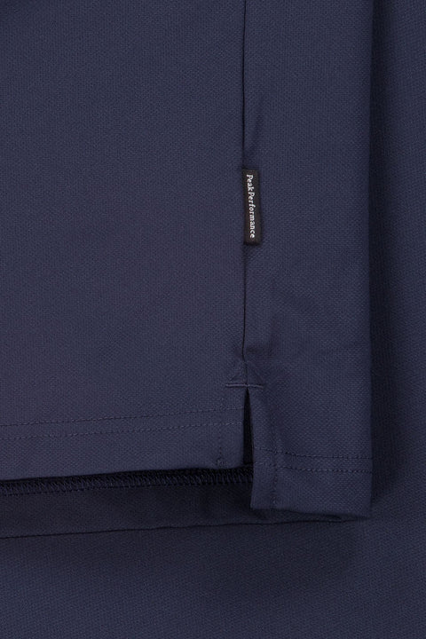 Nahaufnahme eines dunkelblauen Sweatshirts oder Pullovers mit sichtbarem 'Peak Performance' Etikett und detaillierter Ansicht der Stofftextur und Nähte