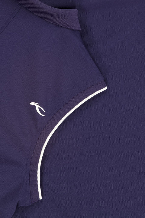 Nahaufnahme eines dunkelblauen Poloshirts mit weißen Kontrastnähten an der Seite und kleinem weißem Logo auf der Brust