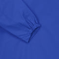 Nahaufnahme eines blauen Kleidungsstücks mit elastischem Gummizug am Ärmel, zeigt Details der Verarbeitung und Stofftextur