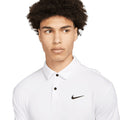 Junger Mann mit lockigem Haar trägt ein weißes Nike Poloshirt