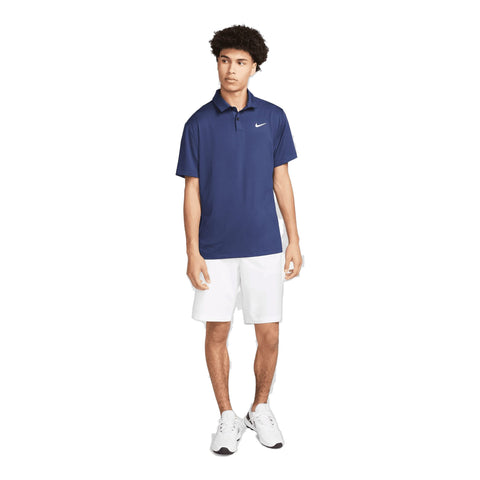 Junger Mann trägt blaues Nike Poloshirt und weiße Shorts