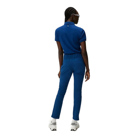 Rückansicht einer Person in blauem Sportoutfit mit weißen Turnschuhen