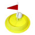 Miniature golf hole with red flag and white golf ball on yellow base, isolated on white background.