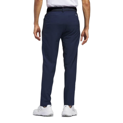 Dunkle Herrenhose von Adidas mit weißen Sportschuhen, von hinten fotografiert